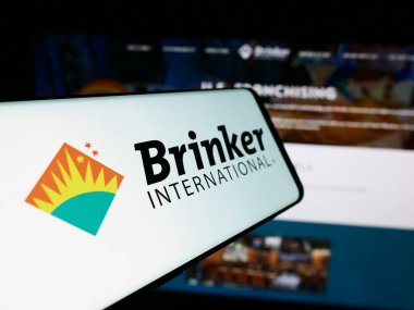 Stuttgart, Germany - 07-05-2024: Mobile phone with logo of American hospitality company Brinker International Inc. in front of website. Focus on center-left of phone display. clipart