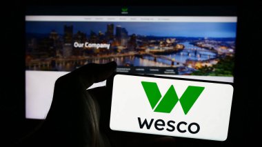 Stuttgart, Almanya - 07-05-2024: İnternet sitesi önünde ABD 'li elektronik şirketi WESCO International Inc.' in logosuna sahip kişi. Telefon ekranına odaklan.
