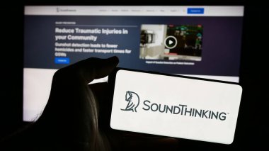 Stuttgart, Almanya - 07-05-2024: İnternet sayfası önünde üzerinde SoundThinking Inc. 'in logosu bulunan cep telefonu sahibi kişi. Telefon ekranına odaklan.