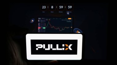 Stuttgart, Almanya - 07-05-2024: İş sayfasının önünde şifreli takas şirketi Pullix Prime Trading Ltd. 'nin logosuna sahip kişi. Telefon ekranına odaklan.