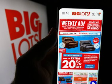 Stuttgart, Almanya - 07-06-2024: ABD 'li indirimli perakende satış şirketi Big Lots Stores Inc.' nin web sayfası ile akıllı telefon sahibi kişi logonun önünde. Telefon ekranının merkezine odaklan.