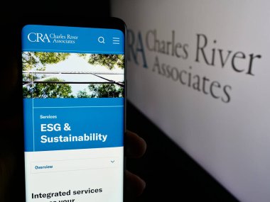 Stuttgart, Almanya - 07-06-2024: Logonun önünde CRA International Inc. (Charles River Associates) web sayfası ile akıllı telefon tutan kişi. Telefon ekranının merkezine odaklan.