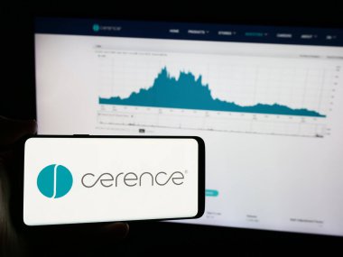 Stuttgart, Almanya - 07-06-2024: Amerikan otomotiv yazılım şirketi Cerence Inc. 'in logosuna sahip cep telefonu sahibi kişi iş sayfasının önünde. Telefon ekranına odaklan.
