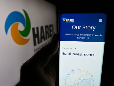 Stuttgart, Almanya - 07-08-2024: Cep telefonunda Harel Sigorta Yatırımları ve Mali Hizmetler Ltd. 'nin logolu web sayfası bulunan kişi. Telefon ekranının merkezine odaklan.