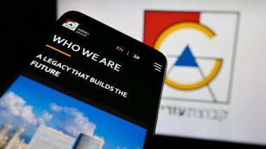 Stuttgart, Almanya - 07-08-2024: İsrailli emlak şirketi Azrieli Group Ltd. 'nin web sitesi ile birlikte iş logosu önünde cep telefonu. Telefon ekranının sol üst kısmına odaklan.