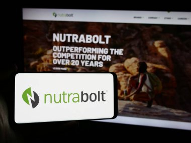 Stuttgart, Almanya - 07-10-2024: İnternet sayfası önünde Amerikan Woodbolt Distribution LLLC (Nutrabolt) logosuna sahip cep telefonu sahibi kişi. Telefon ekranına odaklan.