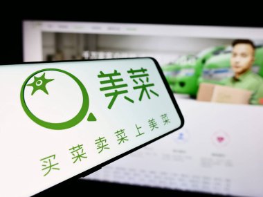 Stuttgart, Almanya - 07-10-2024: Çinli tarım e-ticaret şirketi Meicai 'nin logosunun yer aldığı cep telefonu. Telefon ekranının soluna odaklan.