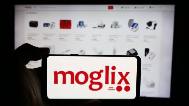 Stuttgart, Almanya - 07-11-2024: E-ticaret şirketi Mogli Labs 'in (Hindistan) logosuna sahip cep telefonu sahibi kişi Ltd. (Moglix) web sayfasının önünde. Telefon ekranına odaklan.