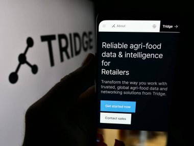 Stuttgart, Almanya - 07-11-2024: Güney Koreli tarım platformu şirketi Tridge Co. Ltd. logolu cep telefonu sahibi kişi. Telefon ekranının merkezine odaklan.