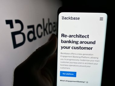 Stuttgart, Almanya - 07-11-2024: Hollandalı fintech şirketi Backbase B.V. 'nin web sayfası ile iş logosu önünde akıllı telefon tutan kişi. Telefon ekranının merkezine odaklan.