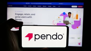Stuttgart, Almanya - 07-11-2024: Amerikan yazılım şirketi Pendo.io Inc. 'in logosuyla cep telefonu sahibi kişi iş sayfasının önünde. Telefon ekranına odaklan.