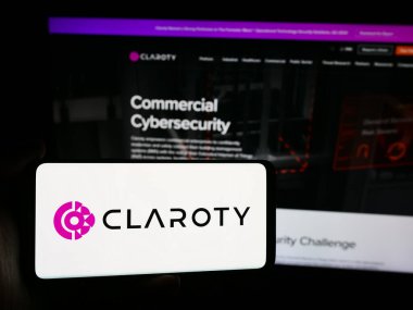 Stuttgart, Almanya - 07-11-2024: İnternet sitesinin önünde üzerinde siber güvenlik şirketi Claroty Ltd. 'nin logosu olan akıllı telefon tutan kişi. Telefon ekranına odaklan.