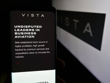 Stuttgart, Almanya - 07-11-2024: Emirati havacılık şirketi Vista Global Holding Limited 'in internet sayfası ile cep telefonu tutan kişi logolu. Telefon ekranının merkezine odaklan.