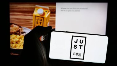 Stuttgart, Almanya - 07-11-2024: ABD 'li gıda teknolojisi şirketi Eat Just Inc. (Sadece Egg)' in logosuna sahip akıllı telefon sahibi kişi web sitesinin önünde. Telefon ekranına odaklan.
