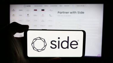 Stuttgart, Almanya - 07-12-2024: ABD 'li emlak komisyoncusu Side Real Estate Inc.' in logosuyla cep telefonu sahibi kişi iş sayfasının önünde. Telefon ekranına odaklan.