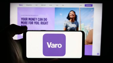 Stuttgart, Almanya - 07-12-2024: ABD 'li finans hizmetleri şirketi Varo Bank N.A.' nın logosuyla cep telefonu tutan kişi İş sayfasının önünde. Telefon ekranına odaklan.