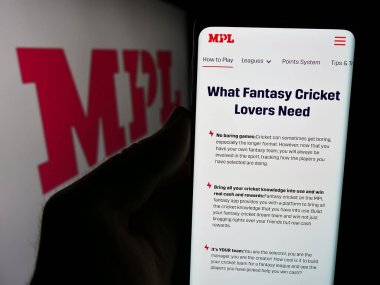 Stuttgart, Germany - 07-14-2024: Person holding cellphone with webpage of Indian online gaming company Mobile Premier League (MPL) with logo. Focus on center of phone display. clipart