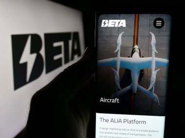 Stuttgart, Almanya - 07-14-2024: Logo önünde ABD 'li eVTOL uçak şirketi Beta Technologies Inc.' nin web sayfası ile akıllı telefon tutan kişi. Telefon ekranının merkezine odaklan.