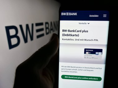 Stuttgart, Almanya - 07-15-2024: Alman şirketi Baden-Wurttembergische Bank 'ın (BW-Bank) logo önünde web sayfası bulunan kişi. Telefon ekranının merkezine odaklan.