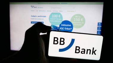 Stuttgart, Almanya - 07-15-2024: Alman finans hizmetleri şirketi BBBank 'ın logosu olan cep telefonu sahibi kişi, iş sayfasının önünde. Telefon ekranına odaklan.