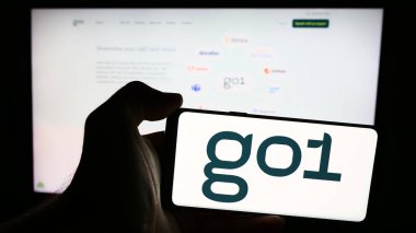 Stuttgart, Almanya - 07-15-2024: Avustralyalı online eğitim şirketi Go1 Pty 'nin logosuna sahip cep telefonu sahibi kişi. Ltd. İş sayfasının önünde. Telefon ekranına odaklan.