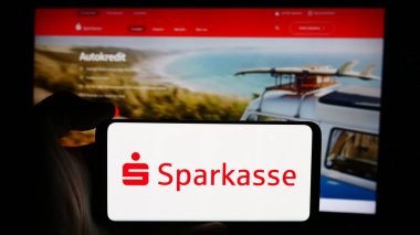 Stuttgart, Almanya - 07-15-2024: Alman finans hizmetleri kurumu Sparkasse 'ın logosuyla cep telefonu tutan kişi iş sayfası önünde. Telefon ekranına odaklan.