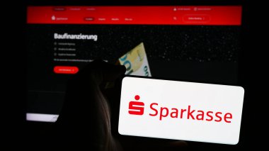 Stuttgart, Almanya - 07-15-2024: Alman finans hizmetleri kurumu Sparkasse 'ın logosunun bulunduğu cep telefonu sahibi kişi iş sayfası önünde. Telefon ekranına odaklan.