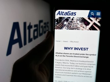 Stuttgart, Almanya - 07-16-2024: Kanadalı enerji altyapı şirketi AltaGas Ltd. 'nin internet sayfası ile logo önünde cep telefonu tutan kişi. Telefon ekranının merkezine odaklan.