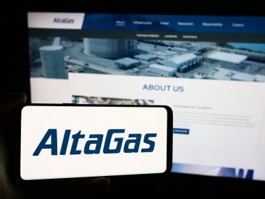 Stuttgart, Almanya - 07-16-2024: Kanadalı enerji altyapı şirketi AltaGas Ltd. 'nin logosuna sahip akıllı telefon sahibi kişi web sitesinin önünde. Telefon ekranına odaklan.