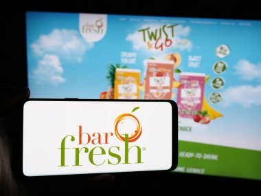 Stuttgart, Almanya - 07-16-2024: İnternet sitesi önünde ABD 'li içecek şirketi Barfresh Food Group Inc. (BRFH) logosuna sahip kişi. Telefon ekranına odaklan.