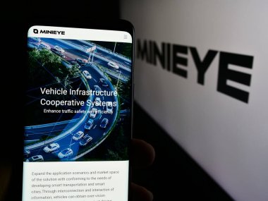 Stuttgart, Almanya - 07-16-2024: Shenzhen Youjia Innov Tech Co. Ltd. (Minieye) adlı şirketin web sayfası ile akıllı telefon sahibi kişi. Telefon ekranının merkezine odaklan.