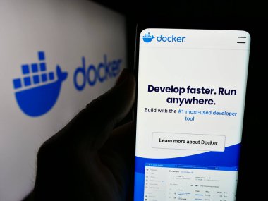 Stuttgart, Almanya - 07-16-2024: ABD 'li üretkenlik yazılım şirketi Docker Inc.' in web sitesi ile logo önünde akıllı telefon tutan kişi. Telefon ekranının merkezine odaklan.