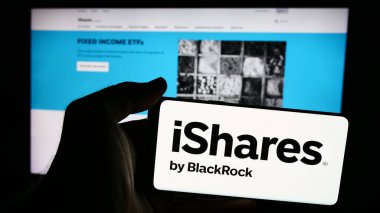 Stuttgart, Almanya - 07-16-2024: Amerikan ETF şirketi iShares (BlackRock Inc.) logosuna sahip cep telefonu sahibi kişi iş sayfasının önünde. Telefon ekranına odaklan.