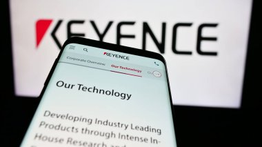 Stuttgart, Almanya - 07-17-2024: Japon elektronik şirketi Keyence Corporation 'ın web sitesi ile birlikte iş logosu önünde cep telefonu. Telefon ekranının sol üst kısmına odaklan.