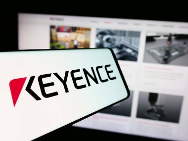 Stuttgart, Almanya - 07-17-2024: Japon elektronik şirketi Keyence Corporation 'ın logosunun yer aldığı akıllı telefon iş web sitesi önünde. Telefon ekranının merkez soluna odaklan.