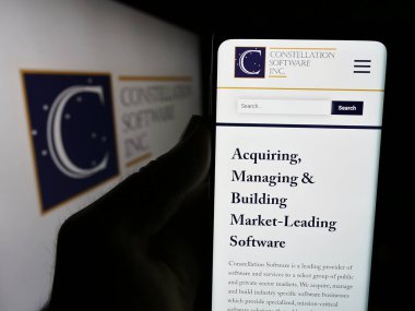 Stuttgart, Almanya - 07-17-2024: İnternet sitesinin önünde Kanadalı şirket Constellation Software Inc. 'in logosuna sahip kişi. Telefon ekranına odaklan.