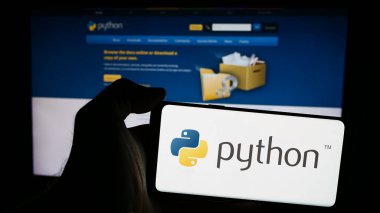 Stuttgart, Almanya - 07-17-2024: İnternet sayfası önünde üzerinde Python Yazılım Vakfı (PSF) logosu bulunan cep telefonu sahibi kişi. Telefon ekranına odaklan.