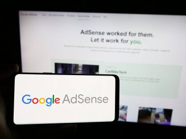 Stuttgart, Almanya - 07-17-2024: İnternet sitesi önünde Google AdSense adlı çevrimiçi reklam programının logosuna sahip kişi. Telefon ekranına odaklan.