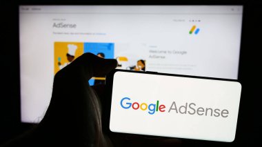 Stuttgart, Almanya - 07-17-2024: İnternet üzerinden reklam programı Google AdSense 'nin logosunu taşıyan cep telefonu sahibi. Telefon ekranına odaklan.