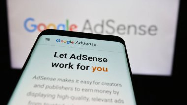 Stuttgart, Almanya - 07-17-2024: İnternet reklam programı Google AdSense 'nin web sitesi ile birlikte iş logosu önünde akıllı telefon. Telefon ekranının sol üst kısmına odaklan.