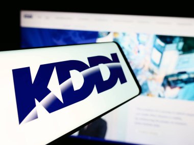 Stuttgart, Almanya - 07-19-2024: Japon telekomünikasyon şirketi KDDI Corporation 'ın logosunun yer aldığı cep telefonu. Telefon ekranının soluna odaklan.