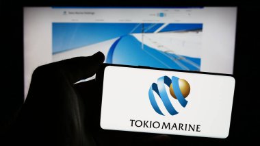 Stuttgart, Almanya - 07-19-2024: İnternet sitesi önünde Japon sigorta şirketi Tokio Marine Holding Inc. 'in logosuna sahip kişi. Telefon ekranına odaklan.