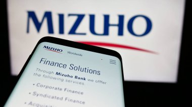 Stuttgart, Almanya - 07-19-2024: Japon bankacılık şirketi Mizuho Financial Group Inc. 'in web sitesi ile birlikte iş logosu önünde cep telefonu. Telefon ekranının sol üst kısmına odaklan.