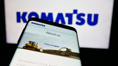 Stuttgart, Almanya - 07-25-2024: Japon ağır ekipman şirketi Komatsu Ltd. 'nin web sitesi ile birlikte ticari logonun önünde akıllı telefon. Telefon ekranının sol üst kısmına odaklan.