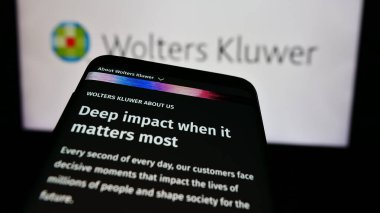 Stuttgart, Almanya - 07-25-2024: Hollandalı bilgi hizmetleri şirketi Wolters Kluwer N.V. 'nin web sayfalı akıllı telefon iş logosu önünde. Telefon ekranının sol üst kısmına odaklan.
