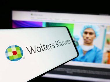 Stuttgart, Almanya - 07-25-2024: Hollandalı bilgi hizmetleri şirketi Wolters Kluwer NV 'nin logolu cep telefonu web sitesi önünde. Telefon ekranının merkez soluna odaklan.