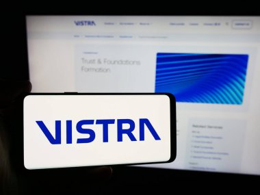 Stuttgart, Almanya - 07-19-2024: İnternet sitesi önünde üzerinde Vistra Group Holding S.A. logosu olan akıllı telefon sahibi kişi. Telefon ekranına odaklan.