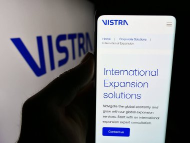 Stuttgart, Almanya - 07-19-2024: Ticari hizmetler şirketi Vistra Group Holding S.A. 'nın logolu internet sitesiyle cep telefonu tutan kişi. Telefon ekranının merkezine odaklan.