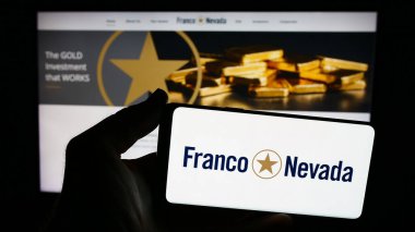 Stuttgart, Germany - 07-19-2024: Person holding smartphone with logo of Canadian gold streaming company Franco-Nevada Corporation in front of website. Focus on phone display. clipart