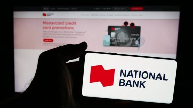 Stuttgart, Almanya - 07-19-2024: İnternet sayfası önünde, finans hizmetleri şirketi National Bank of Canada 'nın (NBC) logosuyla cep telefonu tutan kişi. Telefon ekranına odaklan.